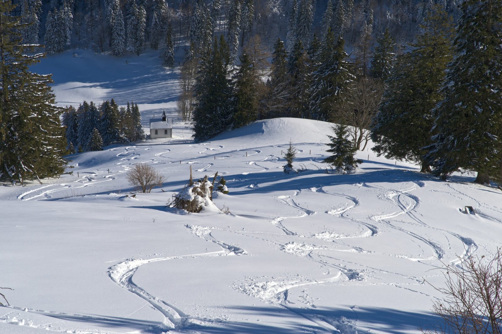 A snow covered hill with a ski lift in the distance