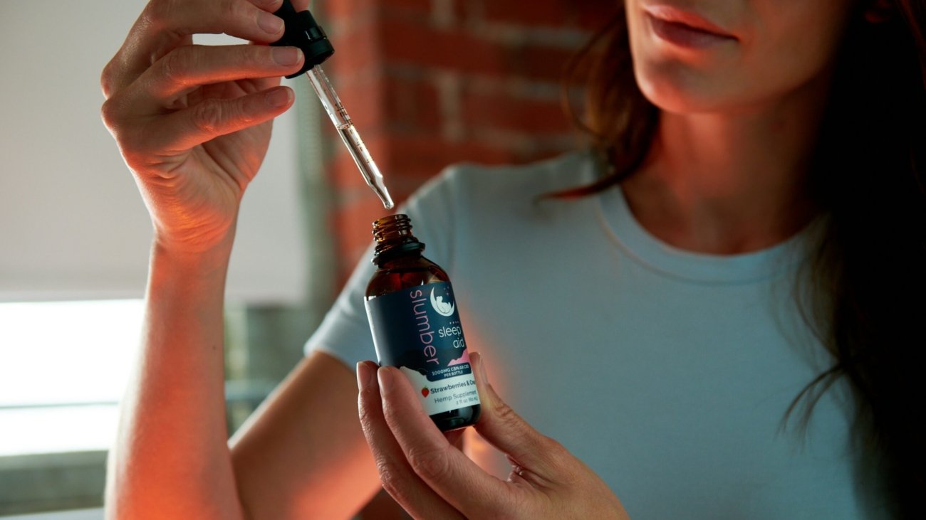 a woman holding a bottle of essential oil