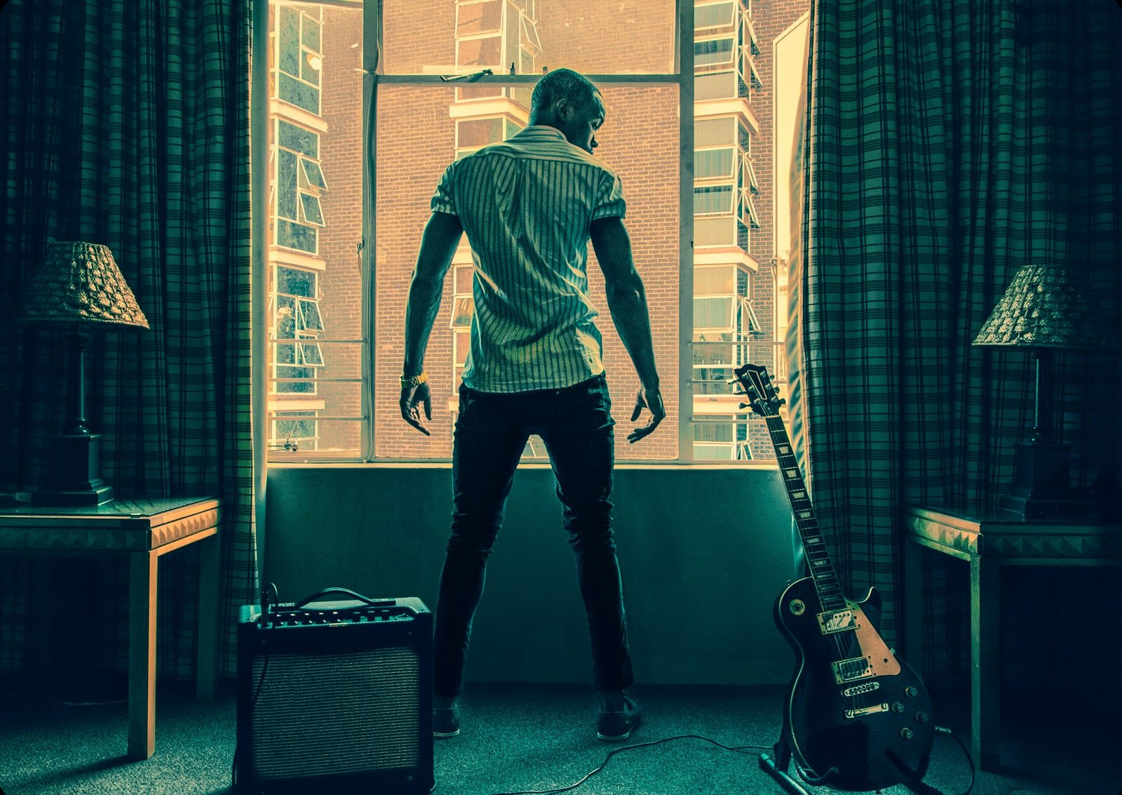 man in white t-shirt and black pants playing guitar