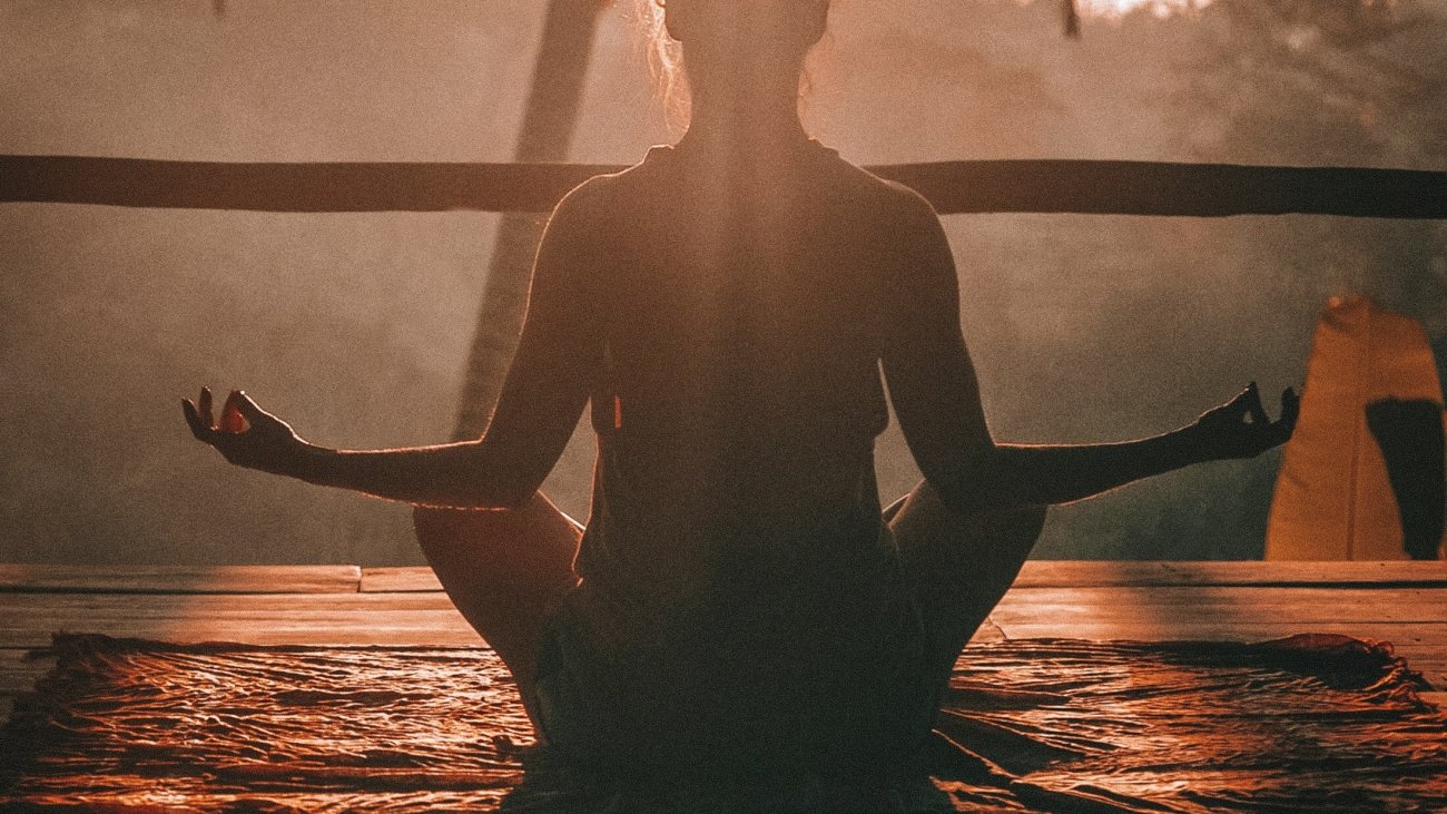 woman doing yoga meditation on brown parquet flooring