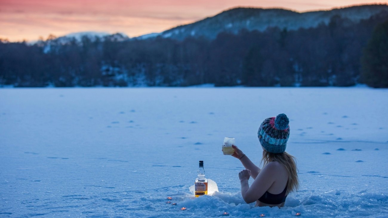 woman in black bikini top holding clear plastic bottle on water